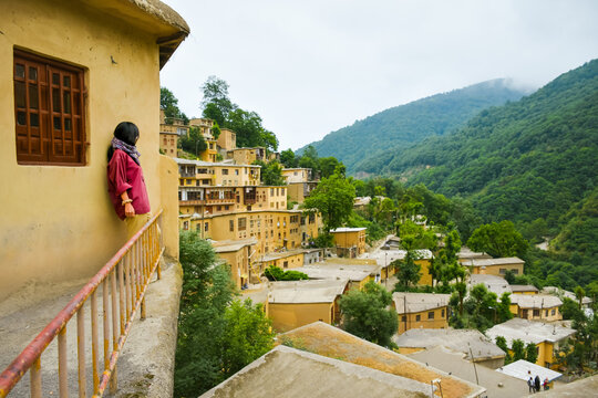 Tourist woman stand enjoy scenic Masuleh village panorama in north east Iran - popular famous tourism destination in persia