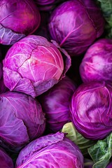 Fototapeta premium A bunch of purple cabbage with a green leaf. The cabbage is fresh and ready to be eaten