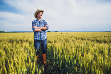 Happy farmer standing in his wheat field.