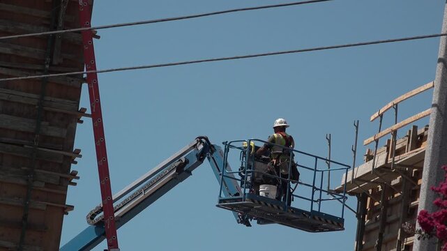 Man working on construction site and using boom lift