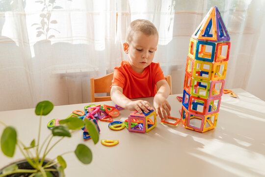 Boy arranging magnet blocks on table