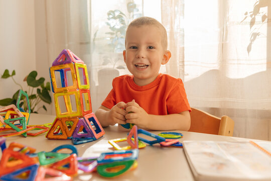 Smiling boy playing with toy blocks at home
