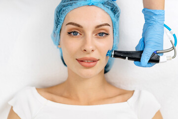 Close-up shot of a young beautiful woman lying on a couch in a cosmetology center. Young woman doing hydrofacial therapy in beauty spa.