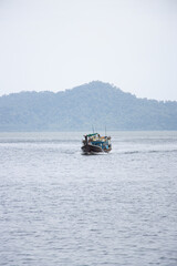 Obraz premium A boat, far away, in Thailand, handled by Burmese workers.