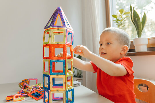 Boy playing with magnet blocks at home