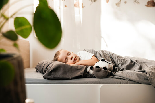 Boy lying on side and sleeping in bed at home
