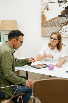 Patient explaining requirements of beauty treatment to doctor in clinic