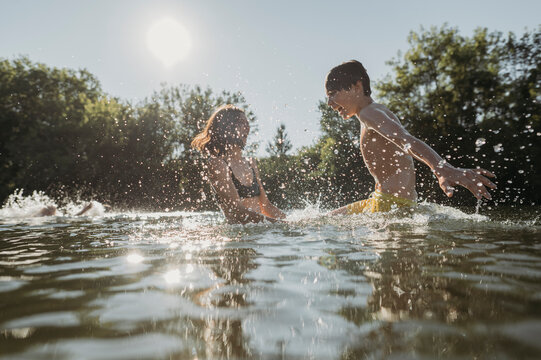 Mother and son playing with water in river