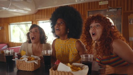 Cinematic footage about a group of multi-ethnic friends eating and having fun in an american styled diner restaurant.