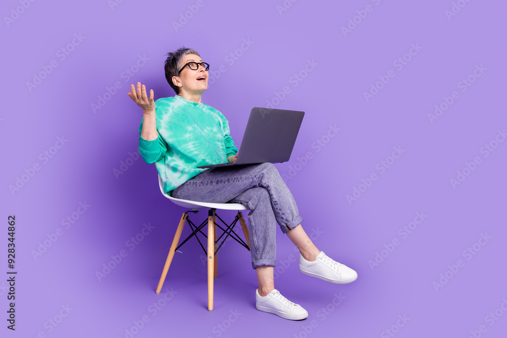 Sticker Full body photo of attractive senior lady sit chair netbook video call look empty space dressed clothes isolated on purple color background