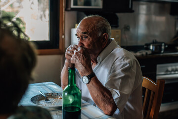 family life of a senior couple at home eating