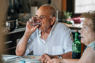 family life of a senior couple at home eating