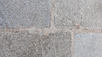 Grey square stone paving slabs with cement grouting