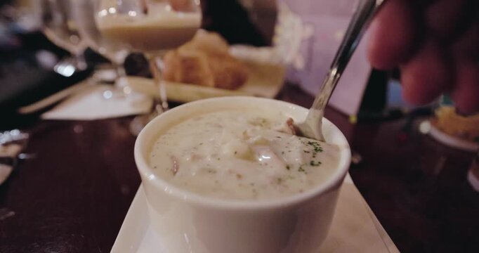 Eating clam chowder in a bowl in restaurant