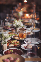 Brunch table setting with different delicious food and beverages ready for friends home party. A variety of food on the table, fish, olives, bread, raspberries, meat. 