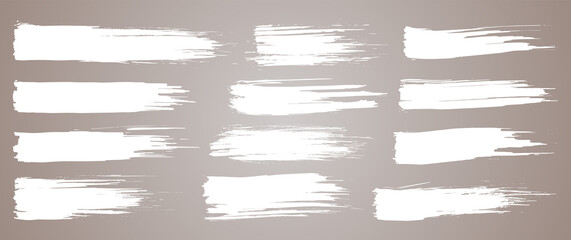Obraz premium Paint brush. White ink grunge brush strokes. paintbrush set. Grunge design elements. Painted ink stripes. Creative isolated spots. Ink smudge abstract shape stains and smear set