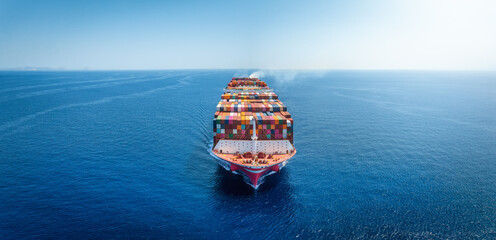 Front view of a large container cargo ship traveling over the calm sea as a banner with copy space
