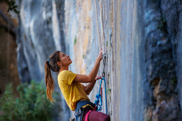  girl climbs a rock. rock climber girl. rock climbing as an Olympic sport.