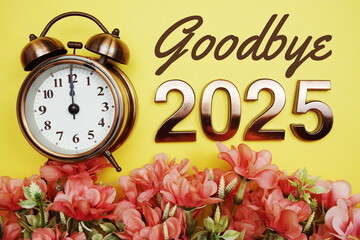 Goodbye 2025 text with alarmclock and flower decoration on yellow background
