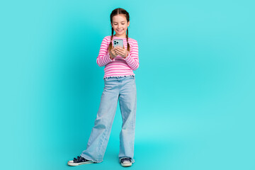 Photo of cute adorable cheerful girl daughter wear trendy pink clothes hold gadget isolated on cyan color background