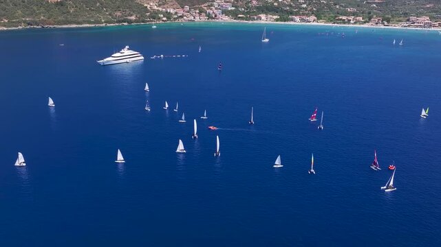 Aerial view of the bay at Vassiiki with numerous windsurfers and sailboats practicing, Lefkada island, Greece