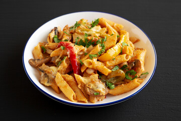Homemade Fajita Pasta Bake on a Plate on a black background, side view.