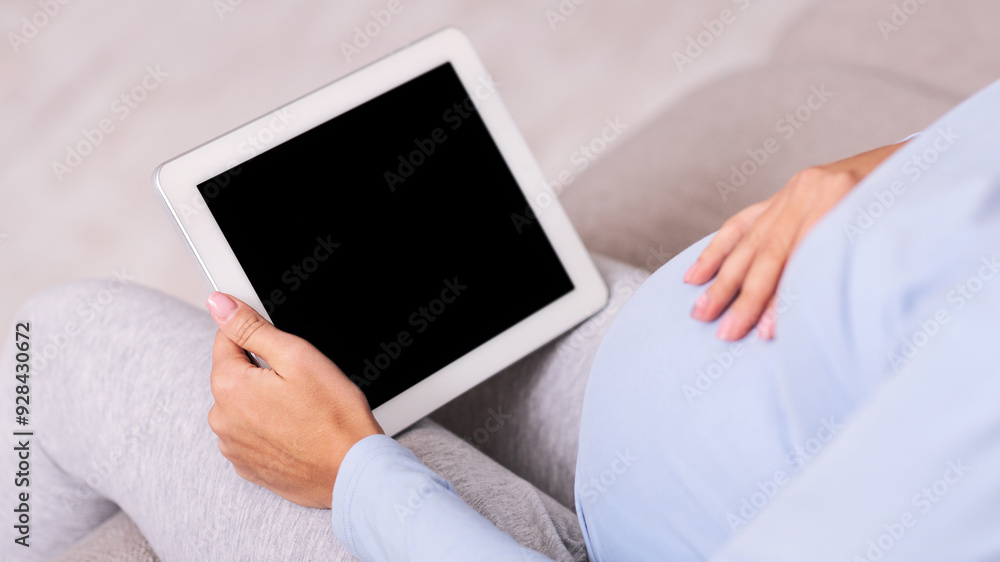 Poster pregnancy app. unrecognizable expectant lady using digital tablet with empty screen sitting on couch