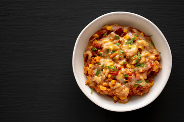 Homemade One-Pot Cheesy Taco Pasta in a Bowl on a black background, top view. Copy space.