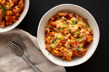 Homemade One-Pot Cheesy Taco Pasta in a Bowl on a black background, top view.