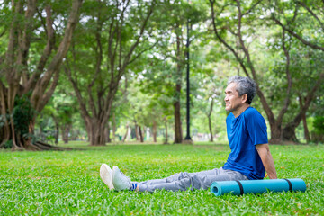 healthy asian senior man in sportswear after did yoga tranquil sitting in the nature park,elderly lifestyle,health care,relaxing