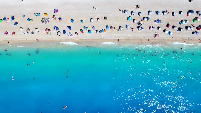 Aerial overhead view of people enjoying the turquoise sea at Egremni Beach, Lefkada island, Greece