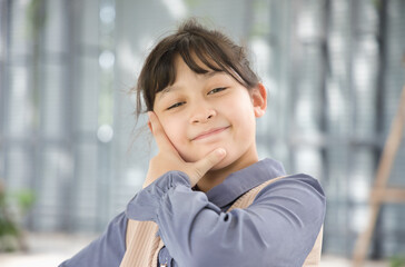Happy smiling casual asian little girl pointing finger up