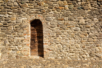 Medieval stone wall with wooden door. Torrechiara Castle, Langhirano, Parma regione, Italy.