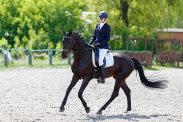 Young equestrian girl performing her dressage test in equestrian competition