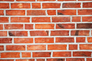 Red brick wall texture background with weathered bricks, cement joints, and an aged, grungy appearance