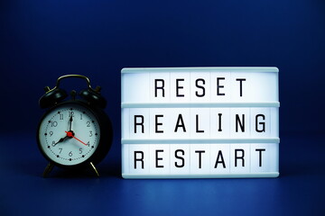 Reset Realing Restart letterboard text on LED Lightbox and alarm clock on blue background