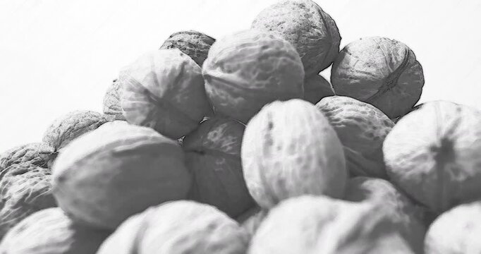 Black white Walnuts rotation, side view, seamless loop Pencil sketch art style. Pile of nuts. Background for advertising natural nutrition, raw food.