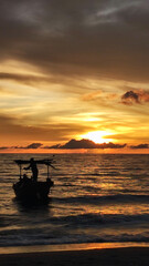 Silhouette people in the boat against sunset at the beach 