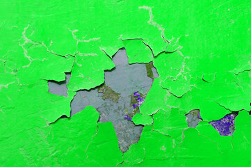 Peeling paint of green and purple colors on the stone texture background, peeling paint texture