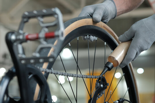 The service center. Bicycle maintenance. The mechanic greases the chain, holds an oil can in his hand.