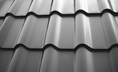 Close-up view lightweight steel roofing sheet. Black color coated modular tile effect roof panel....
