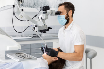 Professional bearded male dentist using modern technologies in dental treatment, complicated cases...