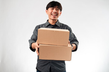 Asian man in a dark gray shirt holding out a plain cardboard box with both hands, standing against a white background. The box is central to the image, suggesting delivery, packaging, or a gift.