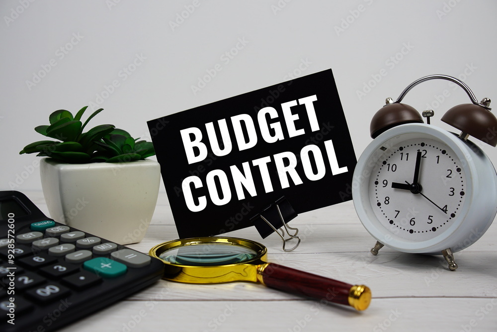 Poster budget control text message with calculate, alarm clock and magnifying glass on wooden background