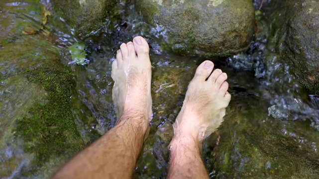 Pies refresc&aacute;ndose en un r&iacute;o natural en el bosque. Visto en primera persona.