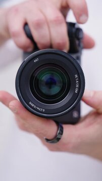 Vertical - person hold camera and manually open and close lens diaphragm blades