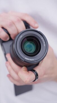 Vertical close up of person change aperture using lens ring, digital camera