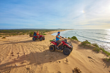 A group of tourists enjoys quad biking along Essaouira's oceanfront