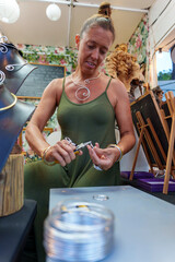 Hispanic Woman in Her 50s Crafting Earrings at Her Street Stall Selling Handmade Aluminum Wire Jewelry