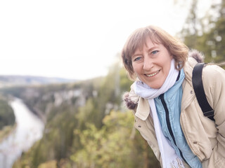 The adventures of a middle-aged female tourist on a trip. A woman smiles while exploring a...